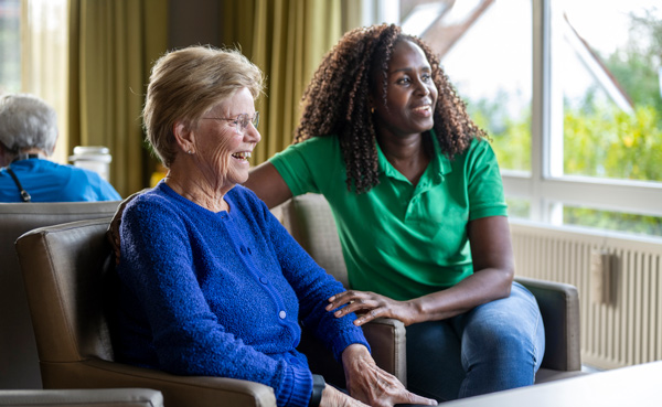 smiling elderly woman with caregiver in cozy setting companionship support wellness