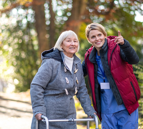 two women outdoors smiling one using walker bright sunny day 8 steps to wellness companionship